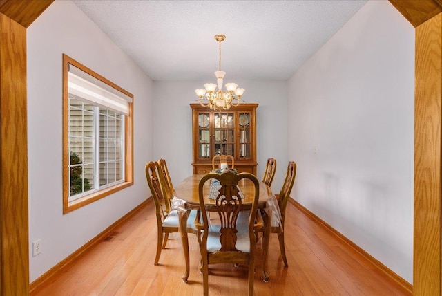 9230 Cheney Trl, Inver Grove Heights, MN 55076 - dining area with a chandelier, light wood-type flooring, and baseboards