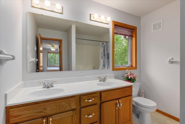 9230 Cheney Trl, Inver Grove Heights, MN 55076 - bathroom with healthy amount of natural light, a textured ceiling, toilet, double vanity, and curtained shower
