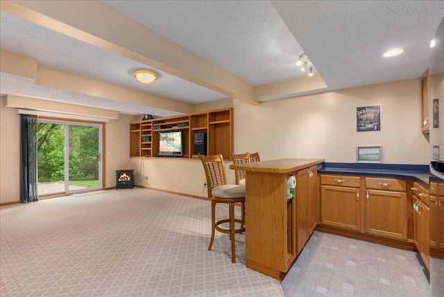 9230 Cheney Trl, Inver Grove Heights, MN 55076 - kitchen with a peninsula, light colored carpet, a textured ceiling, baseboards, and a breakfast bar area