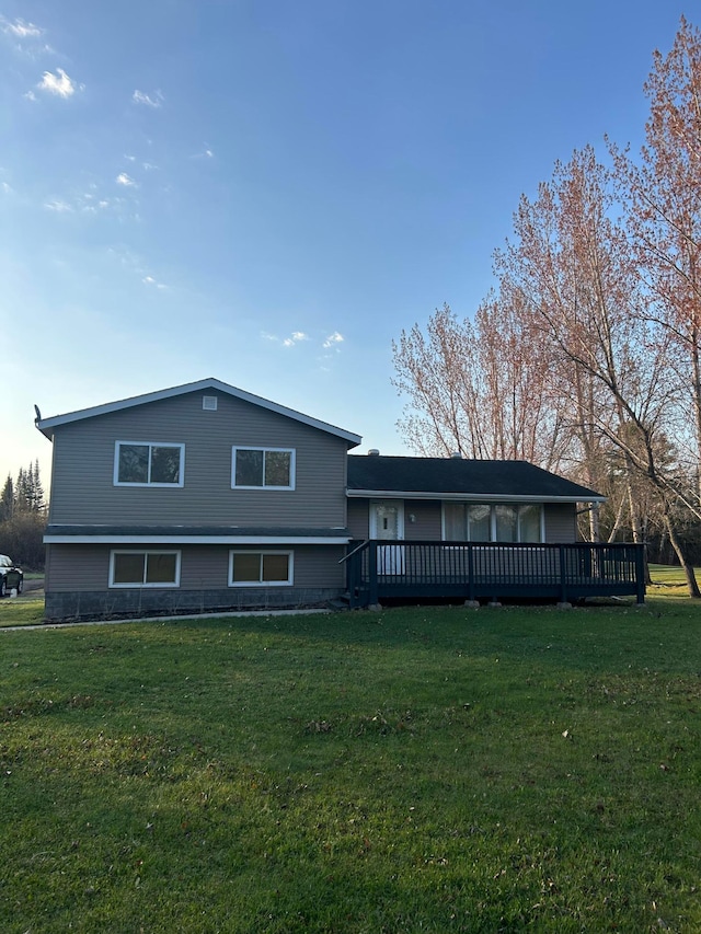 back of house with a wooden deck and a lawn