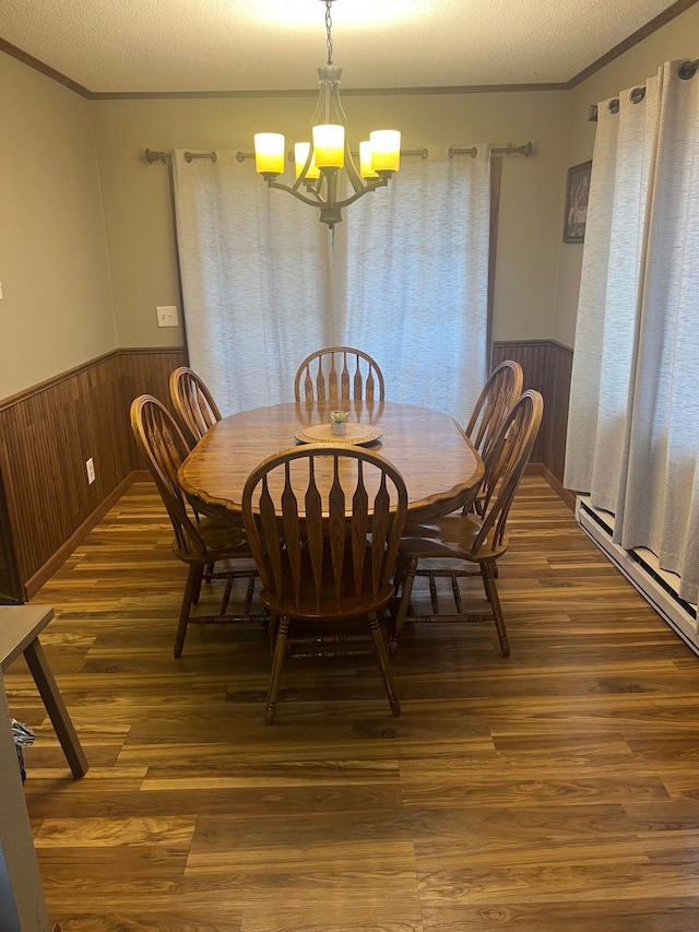 7424 Ely Lake Dr, Fayal Twp, MN 55734 - dining area with crown molding, a chandelier, wainscoting, wood finished floors, and wooden walls