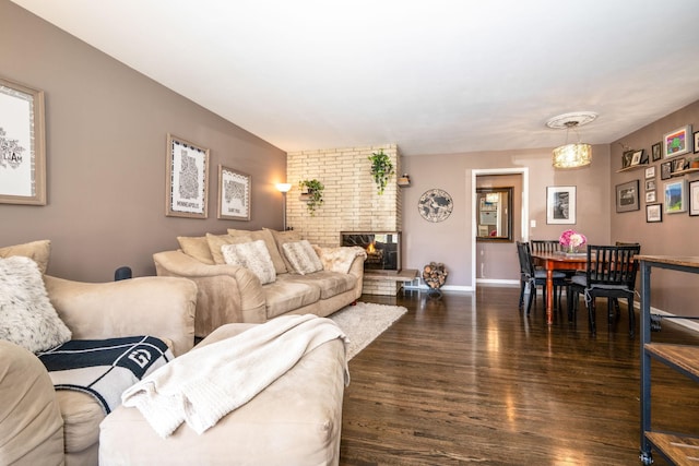 living room featuring dark wood-style flooring, baseboards, and a fireplace