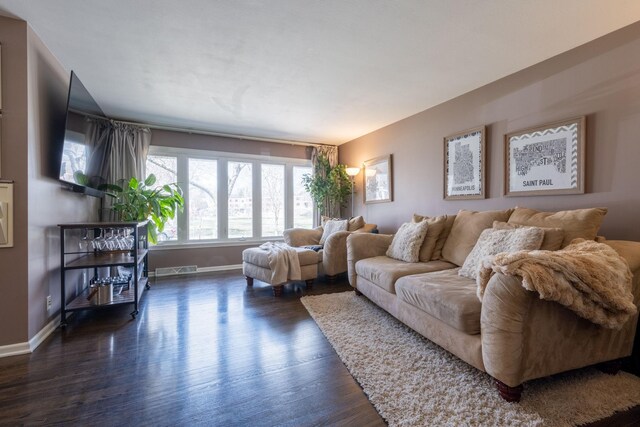 living area with baseboards and wood finished floors