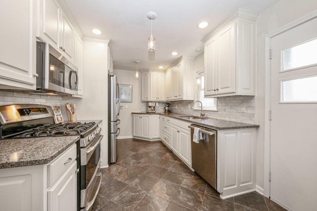 kitchen with stainless steel appliances, a sink, baseboards, white cabinetry, and recessed lighting