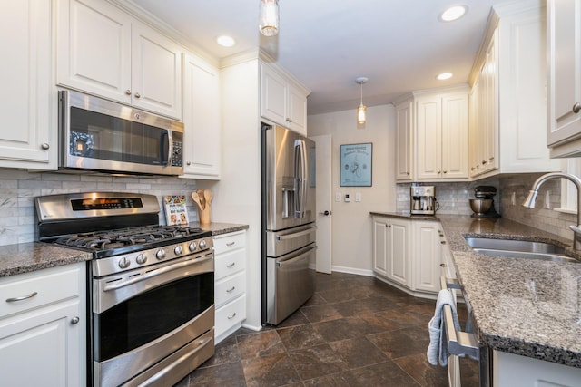 kitchen featuring appliances with stainless steel finishes, a sink, baseboards, white cabinets, and recessed lighting