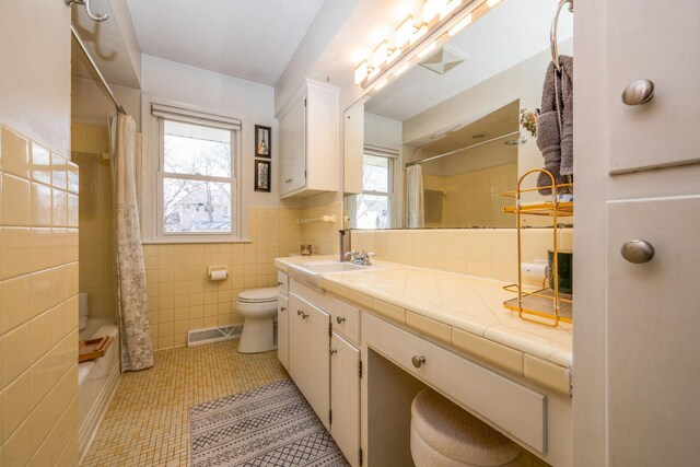 full bath featuring tile walls, toilet, tile patterned flooring, vanity, and shower / bath combination with curtain