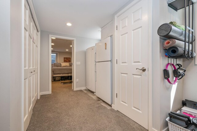 hallway featuring light carpet, recessed lighting, and baseboards