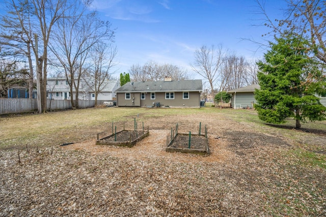 back of house featuring a vegetable garden, a chimney, and central AC unit