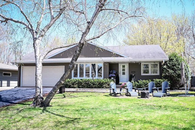 single story home with a garage, asphalt driveway, and a front yard