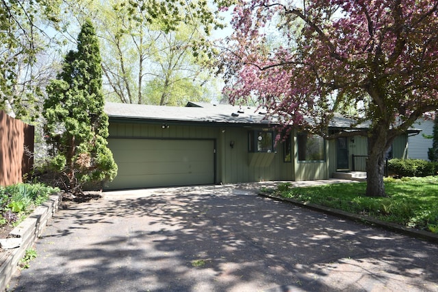view of front of house featuring driveway, a garage, and fence