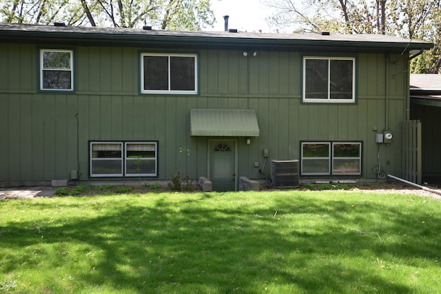 rear view of house featuring a lawn and central AC unit