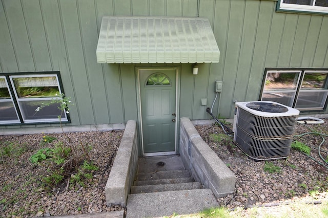 property entrance with central air condition unit and board and batten siding