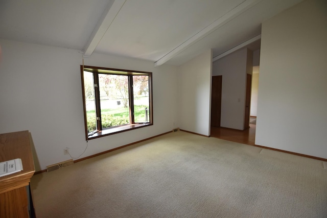 spare room featuring carpet flooring and baseboards