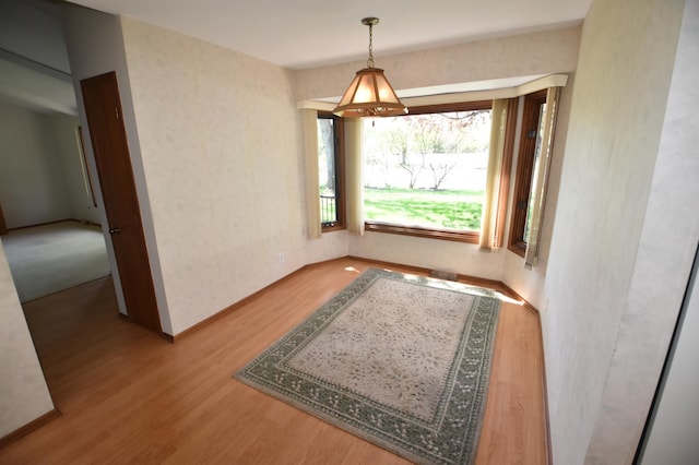 doorway with wood finished floors and baseboards