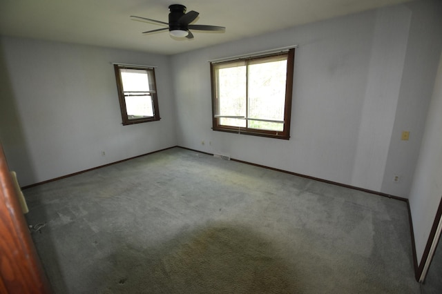 spare room with carpet floors, ceiling fan, and baseboards