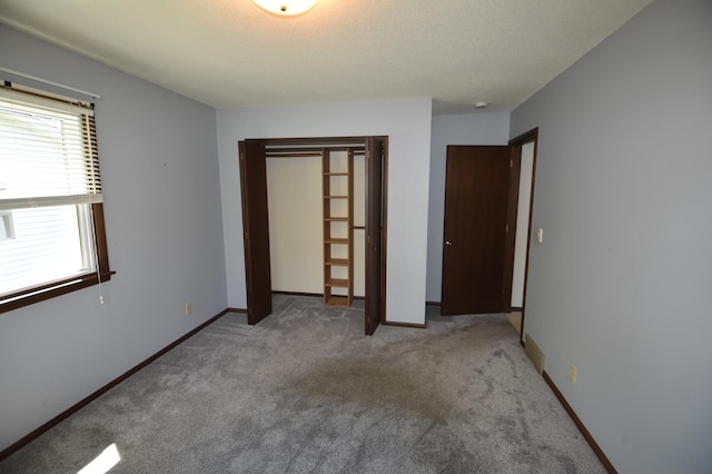 unfurnished bedroom with a closet, carpet, and baseboards