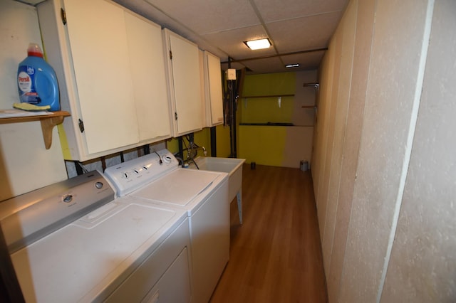 laundry room featuring separate washer and dryer, wood finished floors, and cabinet space