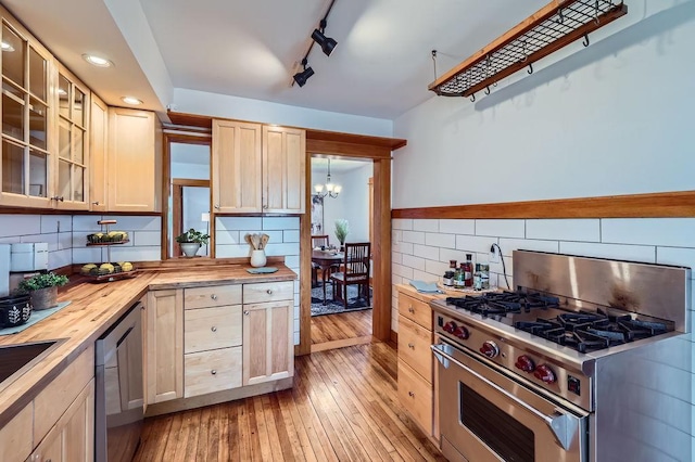 984 Milton St N, Saint Paul, MN 55103 - kitchen featuring appliances with stainless steel finishes, wooden counters, light brown cabinets, a chandelier, and backsplash