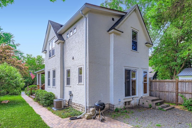 984 Milton St N, Saint Paul, MN 55103 - view of side of home featuring stucco siding and a central air condition unit