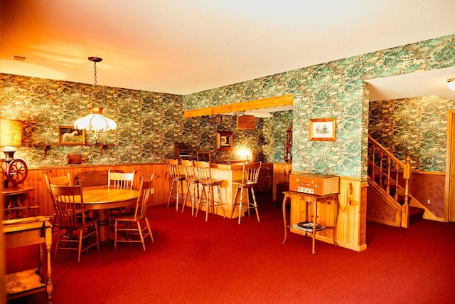 16865 Terrey Pine Dr, Eden Prairie, MN 55347 - dining space with wallpapered walls, a wainscoted wall, stairway, carpet flooring, and a chandelier