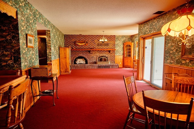16865 Terrey Pine Dr, Eden Prairie, MN 55347 - carpeted dining area with a wainscoted wall, wallpapered walls, a fireplace, a textured ceiling, and a chandelier