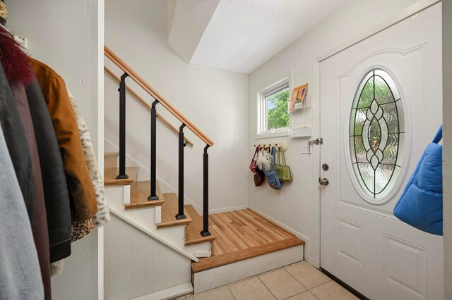 3214 Blaisdell Ave, Minneapolis, MN 55408 - tiled entryway with stairway, a textured ceiling, and baseboards