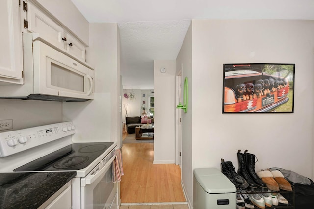 3214 Blaisdell Ave, Minneapolis, MN 55408 - kitchen with white appliances, white cabinetry, light wood-type flooring, a textured ceiling, and baseboards