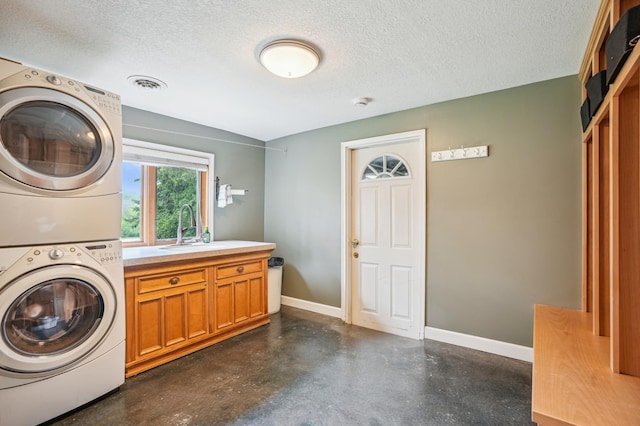 W10005 710th Ave, River Falls, WI 54022 - laundry area with stacked washer and clothes dryer, a textured ceiling, cabinet space, and baseboards