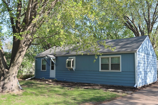 view of front of house with a shingled roof and a front yard