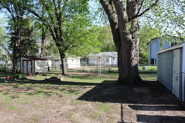 view of yard with a storage unit, fence, and an outdoor structure
