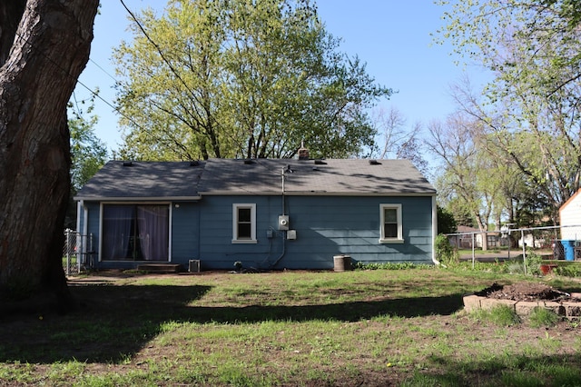 rear view of property with roof with shingles and a chimney
