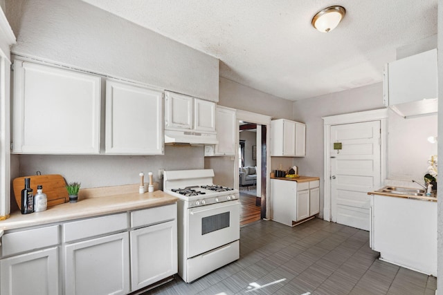 3413 Columbus Ave, Minneapolis, MN 55407 - kitchen featuring white range with gas cooktop, under cabinet range hood, white cabinets, light countertops, and tile patterned floors