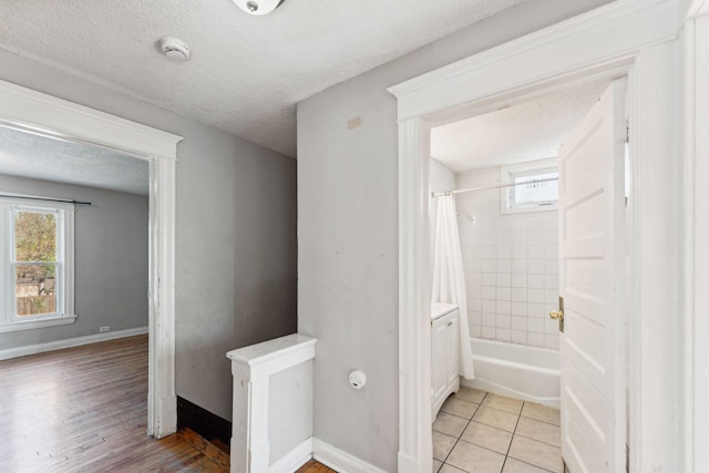3413 Columbus Ave, Minneapolis, MN 55407 - bathroom with a textured ceiling, baseboards, shower / bath combo, and wood finished floors