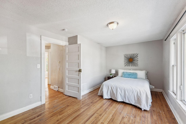 3413 Columbus Ave, Minneapolis, MN 55407 - bedroom with light wood-type flooring, baseboards, and a textured ceiling