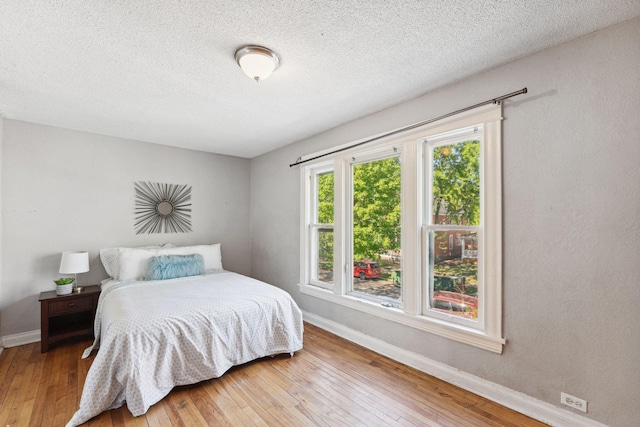 3413 Columbus Ave, Minneapolis, MN 55407 - bedroom featuring baseboards, hardwood / wood-style floors, and a textured ceiling