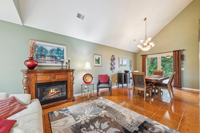 27180 Lakewood Dr NW, Stanford Twp, MN 55040 - living room with baseboards, a chandelier, high vaulted ceiling, tile patterned floors, and a glass covered fireplace