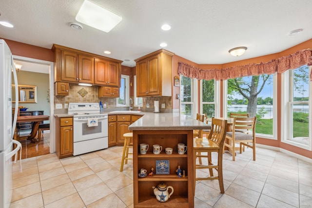 27180 Lakewood Dr NW, Stanford Twp, MN 55040 - kitchen with white appliances, open shelves, a kitchen breakfast bar, backsplash, and brown cabinets