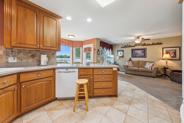 27180 Lakewood Dr NW, Stanford Twp, MN 55040 - kitchen with dishwasher, light colored carpet, a peninsula, brown cabinets, and recessed lighting