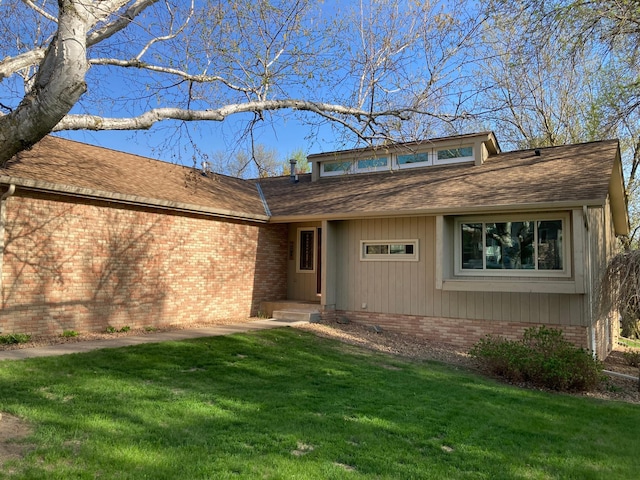 875 20th St, Windom, MN 56101 - view of front facade featuring a front yard, brick siding, and roof with shingles