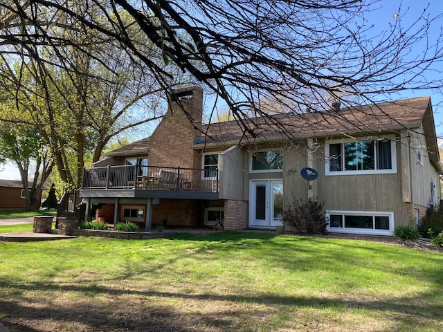 875 20th St, Windom, MN 56101 - back of property featuring a wooden deck, a chimney, a yard, and brick siding