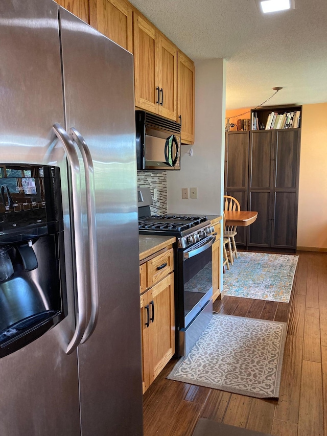 875 20th St, Windom, MN 56101 - kitchen featuring stainless steel appliances, dark wood finished floors, tasteful backsplash, and a textured ceiling