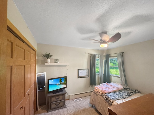 1539 111th St, Slayton Twp, MN 56172 - bedroom with a baseboard heating unit, a textured ceiling, light carpet, a ceiling fan, and baseboards