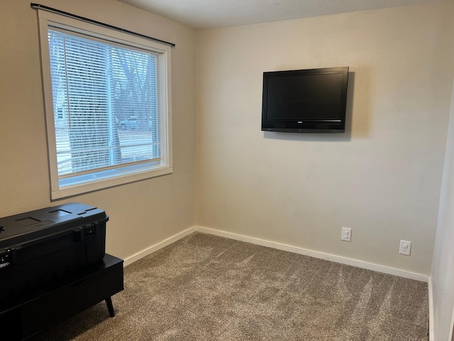 empty room featuring dark carpet and baseboards