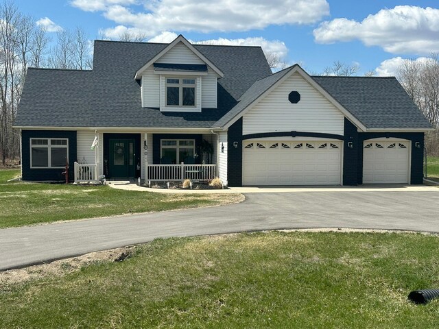 910 Willow Springs Rd, Detroit Lakes, MN 56501 - view of front of home with an attached garage, asphalt driveway, covered porch, a front lawn, and a shingled roof