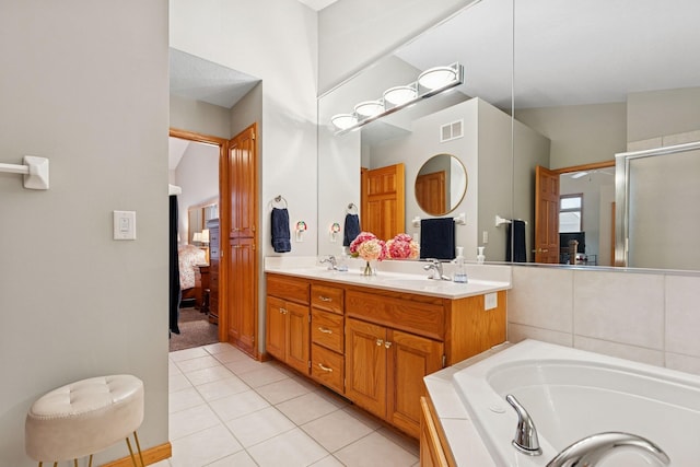full bathroom featuring tile patterned floors, double vanity, a shower stall, a bath, and ensuite bathroom