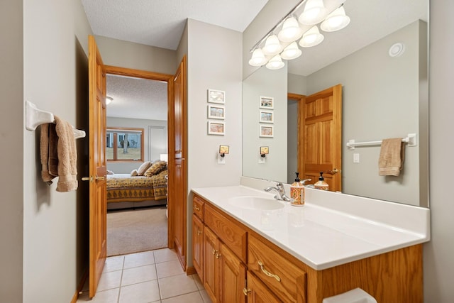 bathroom with a textured ceiling, vanity, tile patterned flooring, and ensuite bath