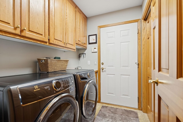 clothes washing area featuring washing machine and clothes dryer, cabinet space, and light tile patterned floors