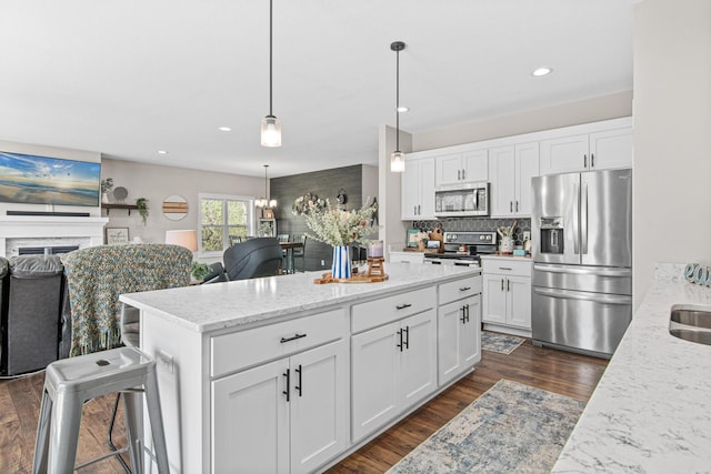 968 150th Ave, New Richmond, WI 54017 - kitchen with appliances with stainless steel finishes, open floor plan, dark wood-style floors, a kitchen island, and recessed lighting