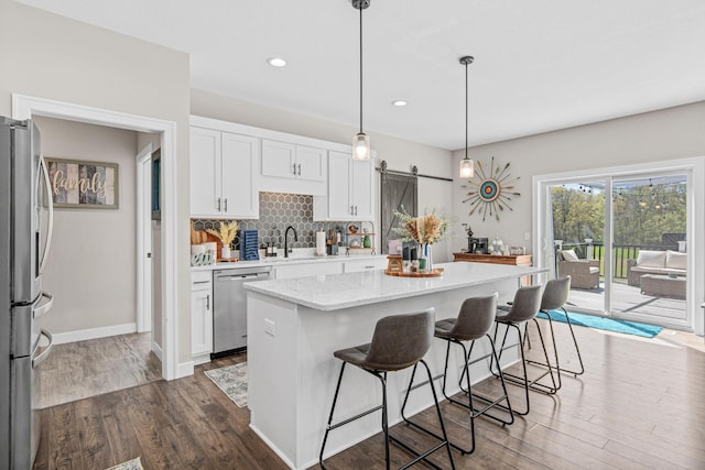 968 150th Ave, New Richmond, WI 54017 - kitchen featuring stainless steel appliances, dark wood-style flooring, white cabinetry, backsplash, and a center island