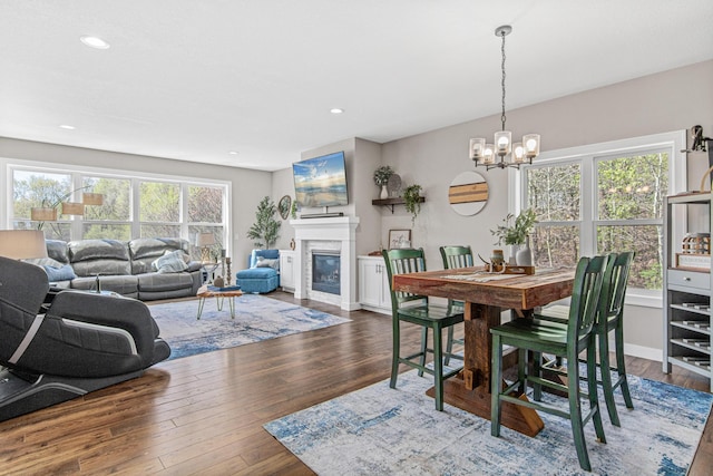 968 150th Ave, New Richmond, WI 54017 - dining area with wood finished floors, a chandelier, recessed lighting, and a glass covered fireplace